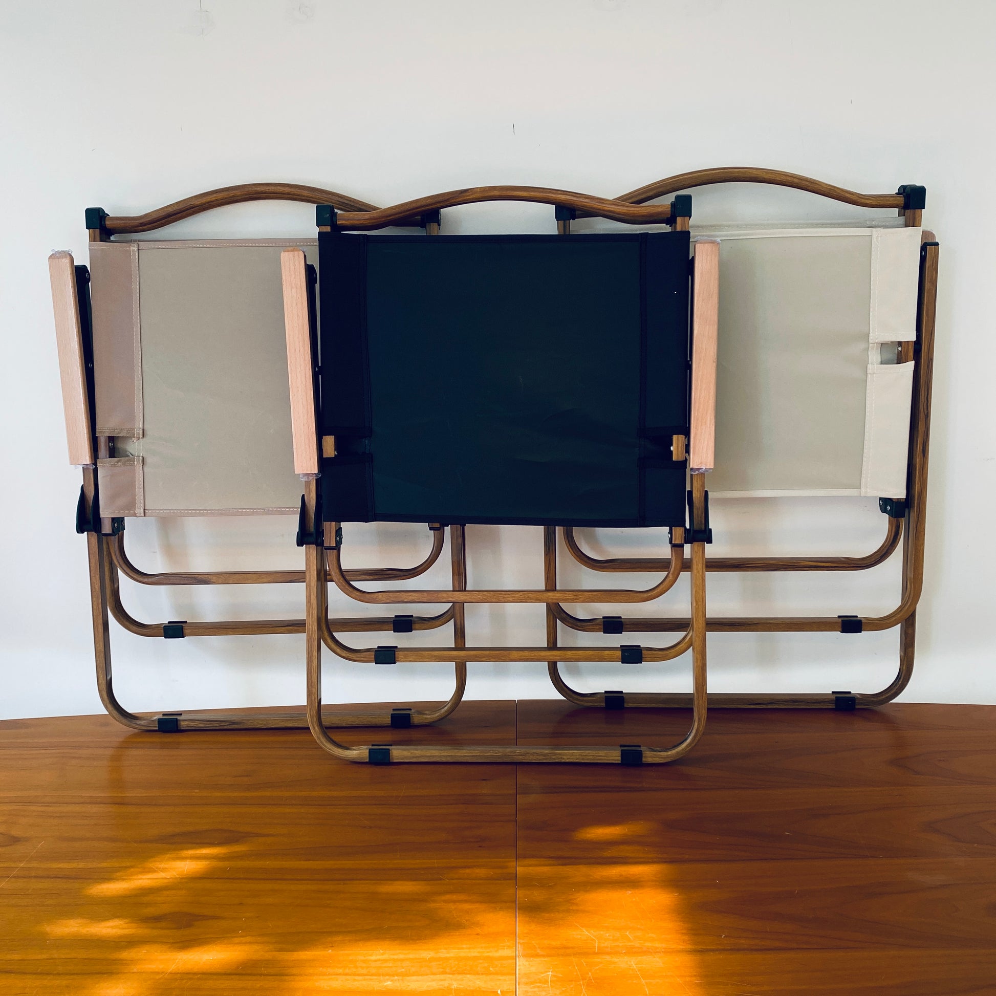 Three lightweight, stylish camping safari chairs, shown folded, by The Well Heeled Hippy Store