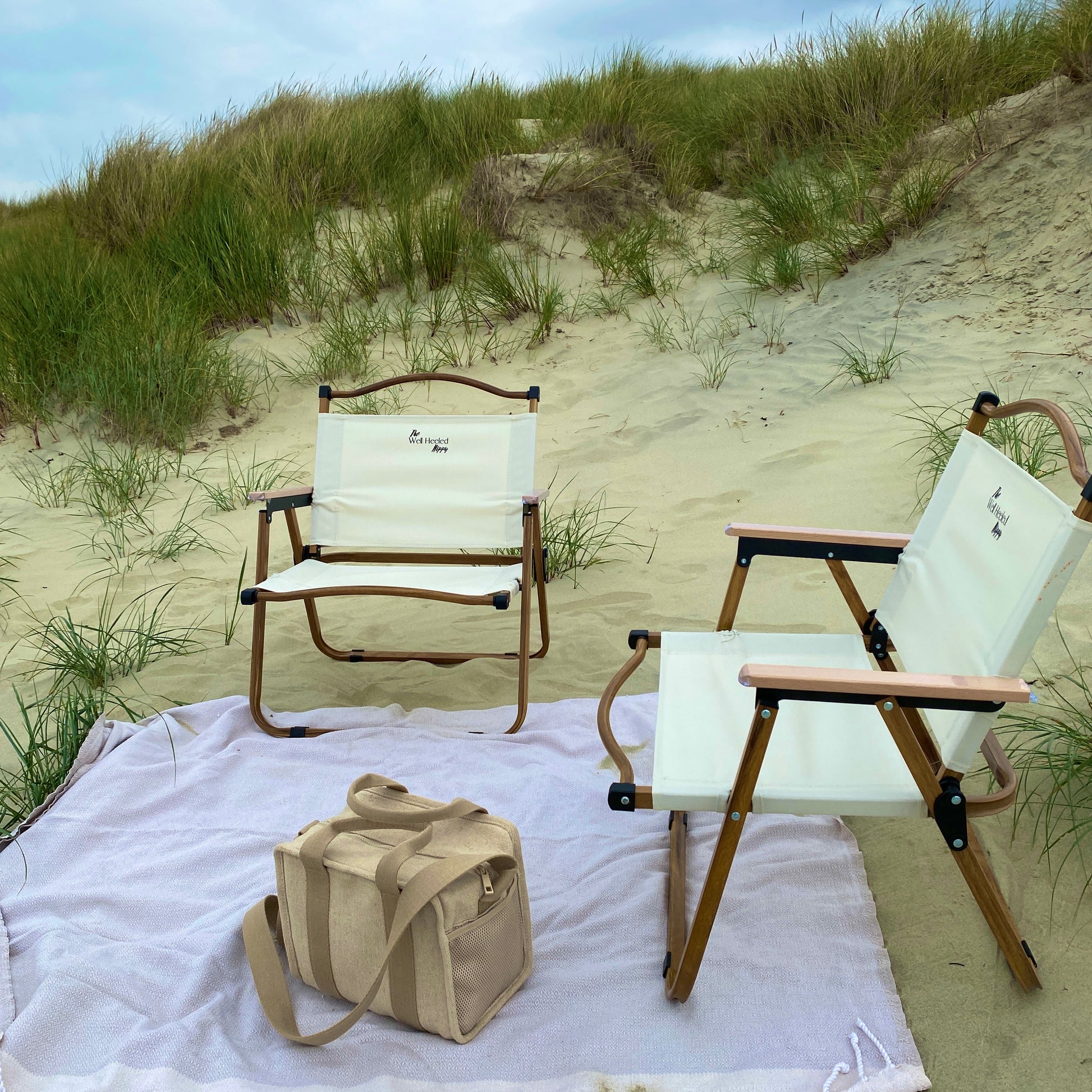 A pair of lightweight, foldable, stylish camping chairs by The Well Heeled Hippy store - a perfect picnic chair for a sandy beach. Shown in beige