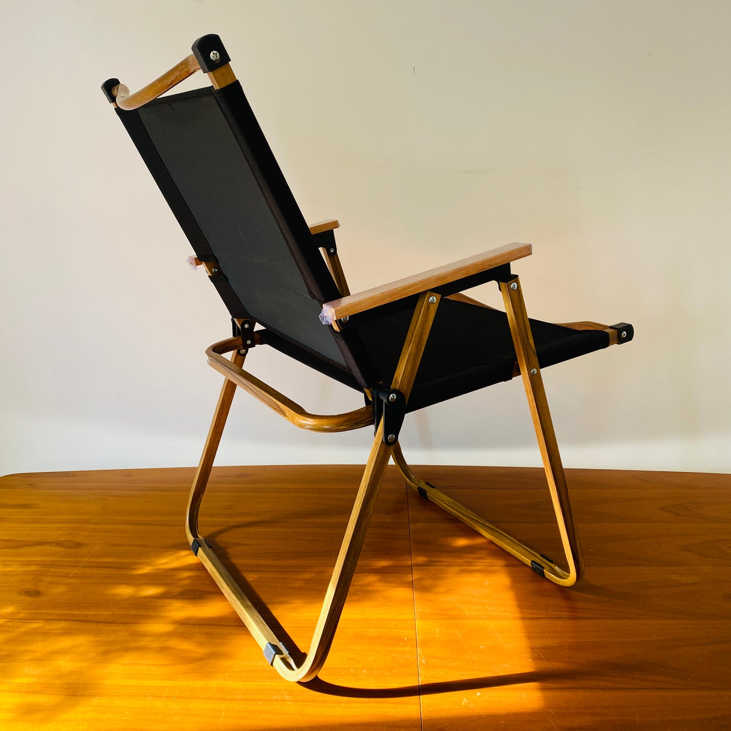 A back view of the foldable, portable, luxury safari chair in black by The Well Heeled Hippy